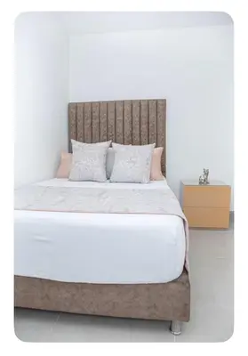 a bedroom with a large bed with a wooden headboard at Apartahotel Ginebra central cerca laureles in Medellín