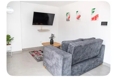a living room with a couch and a tv at Apartahotel Ginebra central cerca laureles in Medellín