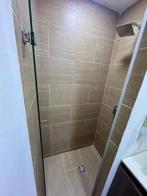 a shower with a glass door in a bathroom at Apartamento Blanco in Medellín