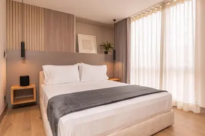 a bedroom with a large white bed and a window at Jatisa Living by Housy in Medellín
