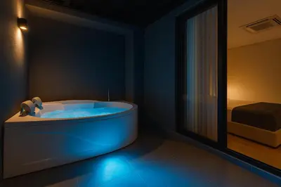 a bathroom with a tub with a bed and a mirror at Jatisa Living by Housy in Medellín