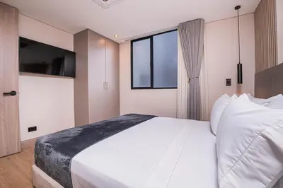 a bedroom with a large white bed and a window at Jatisa Living by Housy in Medellín