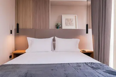 a bedroom with a large bed with white pillows at Jatisa Living by Housy in Medellín
