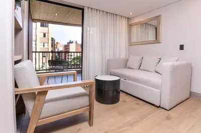 a living room with a couch and a chair at Jatisa Living by Housy in Medellín