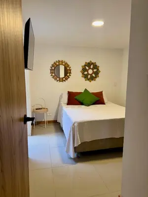 a bedroom with a bed and a mirror on the wall at Apartamento la Sexta in Medellín