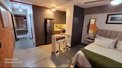 a small bedroom with a bed and a kitchen at Baseloft in Medellín