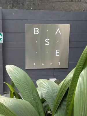 a sign on a wall with plants in front of it at Baseloft in Medellín