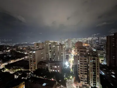 a city lit up at night with tall buildings at Baseloft in Medellín