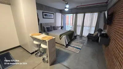 a room with a bed and a couch and a table at Baseloft in Medellín