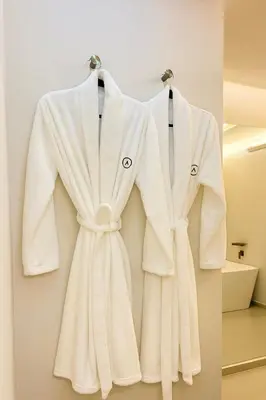 a white robe hanging on a wall at One Apartments Provenza in Medellín