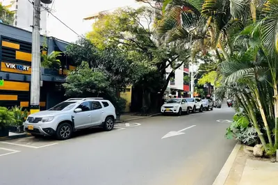 a row of cars parked on the side of a street at One Apartments Provenza in Medellín