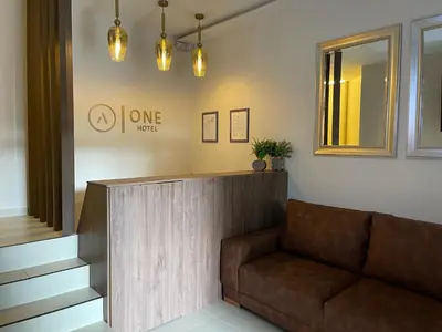 a lobby with a brown couch and a mirror at One Apartments Provenza in Medellín