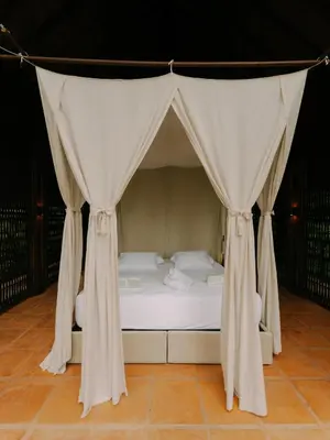 a bed in a tent with curtains around it at Sandagua Hotel-Doradal, Antioquia in Puerto Triunfo