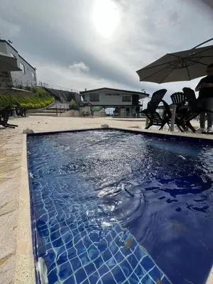 a large swimming pool with blue tiles in a yard at ZOI Eco Hotel y Glamping in Manizales
