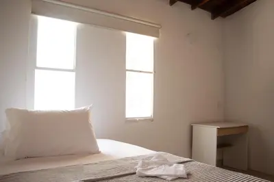 a bedroom with a bed with a pillow and a window at 2 Cuadras Estadio - La 70, Laureles, 700MB, AC in Medellín