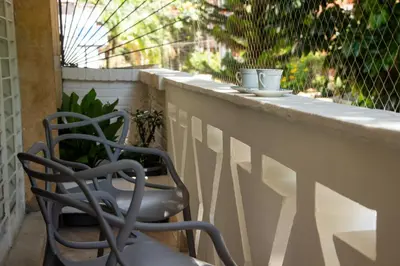 two chairs sitting on a railing on a balcony at 2 Cuadras Estadio - La 70, Laureles, 700MB, AC in Medellín
