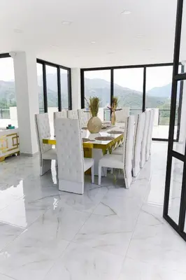 a dining room with a table and white chairs at Finca golden house en santa fe de antioquia in El Espinal