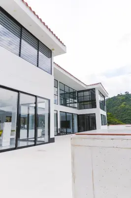 an exterior view of a white building with glass windows at Finca golden house en santa fe de antioquia in El Espinal