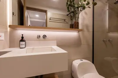 a bathroom with a sink and a toilet and a mirror at 103 Design Loft Escape Hammock AC & Great Vibes in Medellín
