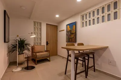 a living room with a table and a chair at 103 Design Loft Escape Hammock AC & Great Vibes in Medellín