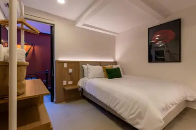 a small bedroom with a bed and a window at 103 Design Loft Escape Hammock AC & Great Vibes in Medellín