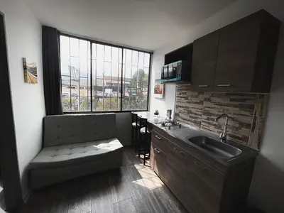 a kitchen with a couch and a sink and a window at Espectacular apartaestudio en envigado cerca de todo in Envigado
