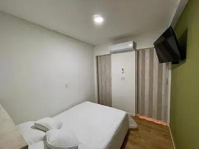 a small room with a bed and a television at Espectacular apartaestudio en envigado cerca de todo in Envigado