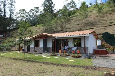 a small house with a person standing in front of it at Alma Casa Finca in Guarne