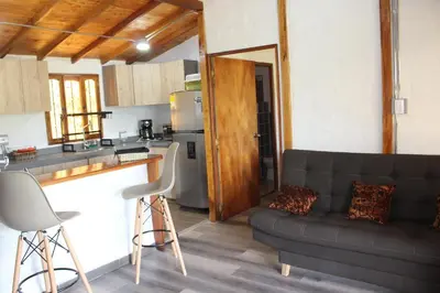 a living room with a couch and a kitchen at Alma Casa Finca in Guarne