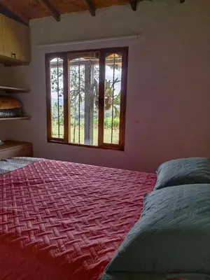 a bedroom with a large bed and a window at Alma Casa Finca in Guarne