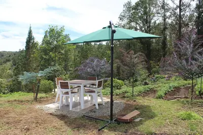 a table and chairs under a green umbrella at Alma Casa Finca in Guarne