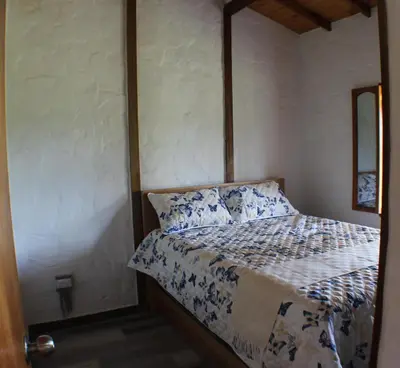 a bedroom with a bed with blue and white sheets at Alma Casa Finca in Guarne