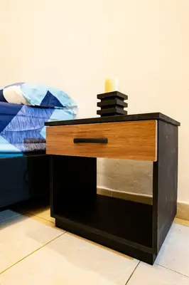 a nightstand with a candle on it next to a bed at La Esquinita de Miraflores in Medellín