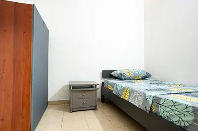 a small bedroom with a bed and a night stand at La Esquinita de Miraflores in Medellín