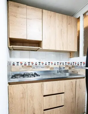 a kitchen with wooden cabinets and a sink at La Esquinita de Miraflores in Medellín