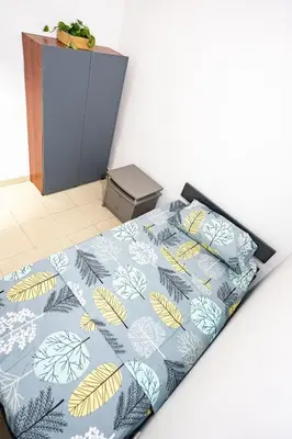 a bed with a blue blanket with leaves on it at La Esquinita de Miraflores in Medellín