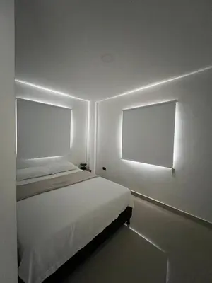 a bedroom with a white bed and a window at Apartamento 2 habitaciones en la América in Medellín