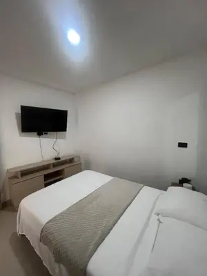 a bedroom with a bed and a flat screen tv at Apartamento 2 habitaciones en la América in Medellín