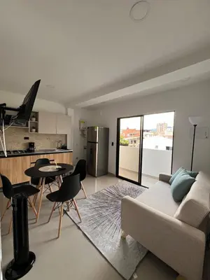 a living room with a couch and a kitchen at Apartamento 2 habitaciones en la América in Medellín