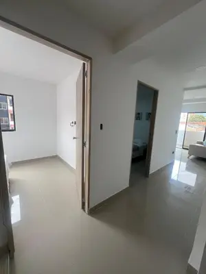 an empty room with a door and a living room at Apartamento 2 habitaciones en la América in Medellín