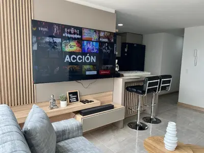 a living room with a couch and a tv and a counter at Apto Moderno,Tranquilo, Avenida las Vegas, cerca al Metro, a 20 min de Provenza in Sabaneta