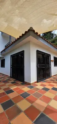 a building with two doors and a checkered floor at Casa Campestre Tara in Barbosa