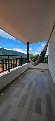 an empty house with a balcony with a hammock at Casa Campestre Tara in Barbosa