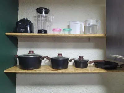 three pots and pans on a shelf in a kitchen at Envigado Centro Piso 1 in Envigado