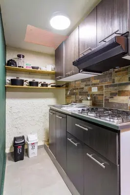 a kitchen with wooden cabinets and a stove top oven at Envigado Centro Piso 1 in Envigado