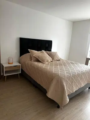 a bed with a black headboard in a bedroom at Apartamento moderno ubicado en zona exclusiva in Manizales