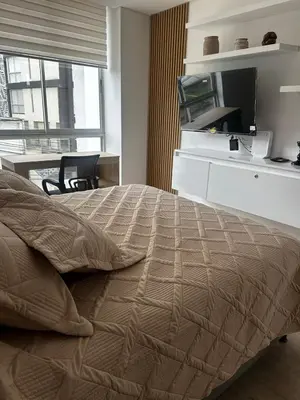 a bedroom with a bed and a desk with a television at Apartamento moderno ubicado en zona exclusiva in Manizales