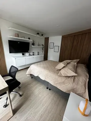 a bedroom with a bed and a television and a desk at Apartamento moderno ubicado en zona exclusiva in Manizales