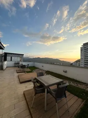 a patio with a table and chairs on a roof at Apartamento moderno ubicado en zona exclusiva in Manizales