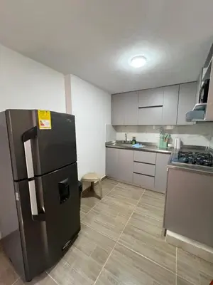 a kitchen with a black refrigerator in a room at Dúplex Céntrico Con Servicios Premium in Medellín
